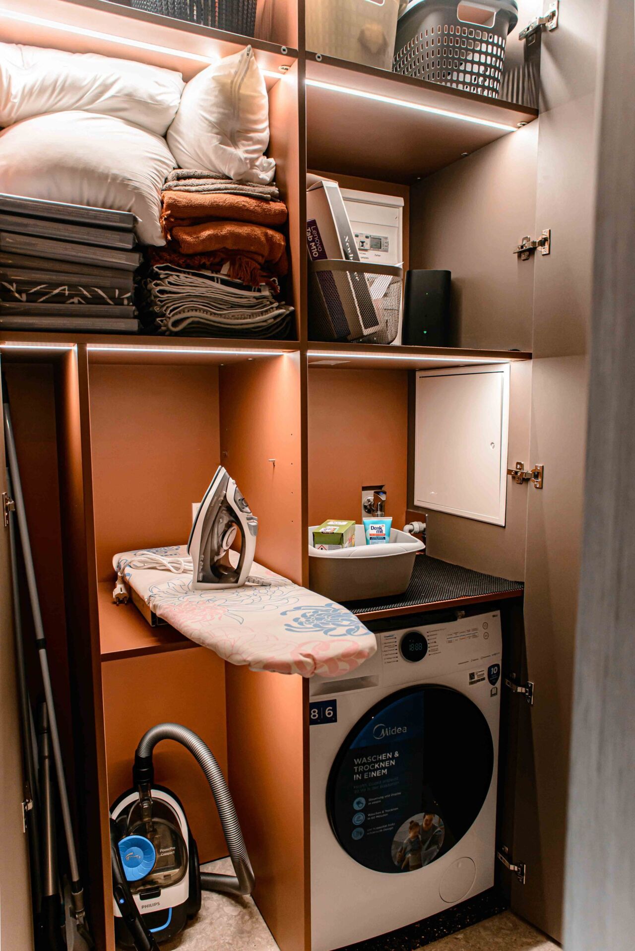 ge&ouml;ffnete Schr&auml;nke mit Waschmaschine in Ferienwohnung